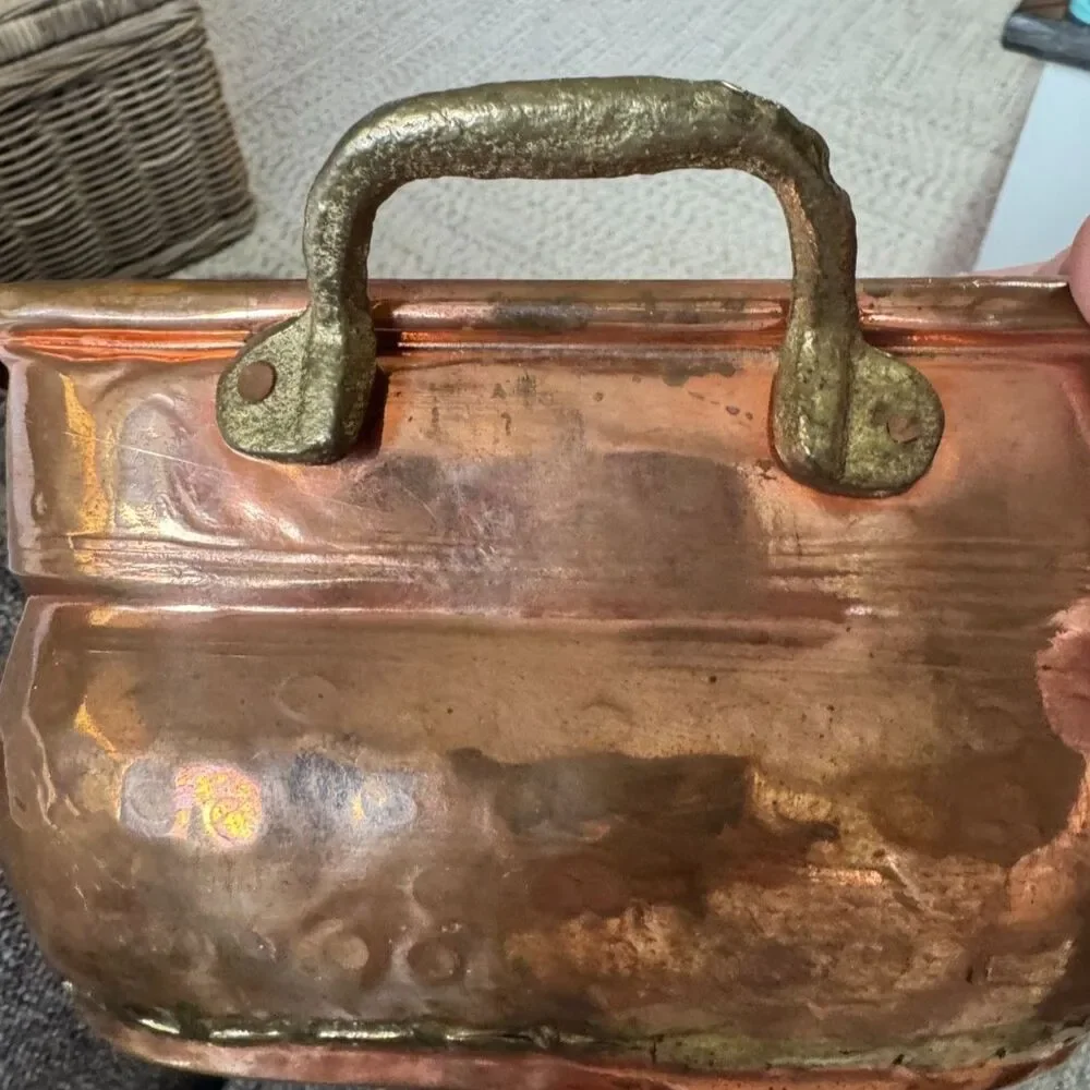 Antique hand-worked copper vessel visible dovetailed/soldered seam, hammered